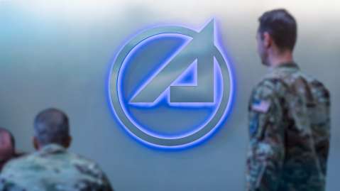 Service members standing next to a wall with the Aerospace circle A logo