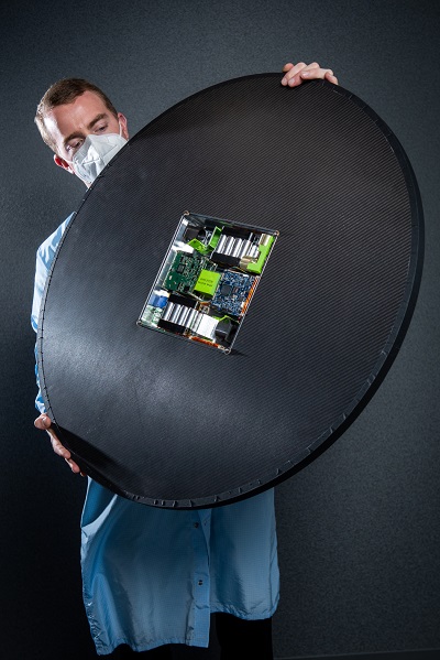 Aerospace engineer holding up DiskSat small satellite.