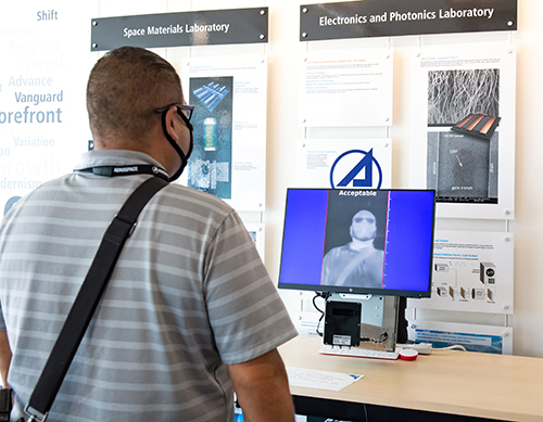 Person being scanned in front of T-case fever indicator stand