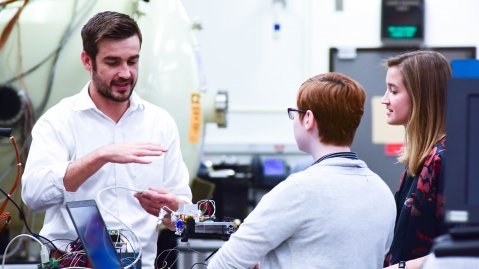 Picture of scientist working with interns on a project