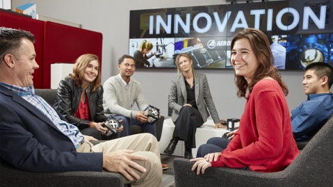 Team engaging in conversation with young woman looking off camera