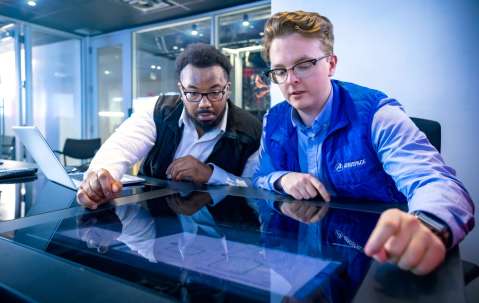 Two Aerospace employees looking at a screen together