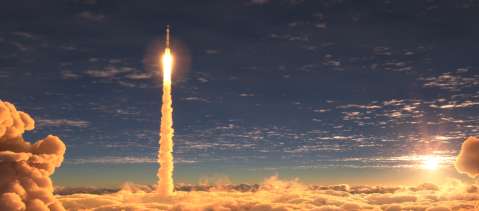 Rocket launch above clouds at sunset