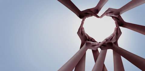 Group of hands that form the shape of a heart