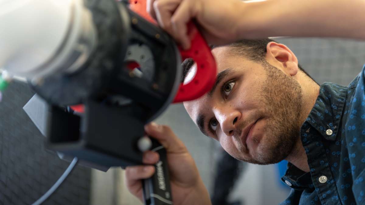 Alonzo Lopez, a member of the technical staff, adjusts a robotic arm in xLab, the prototyping facility at Aerospace. [Nov. 14, 2019]