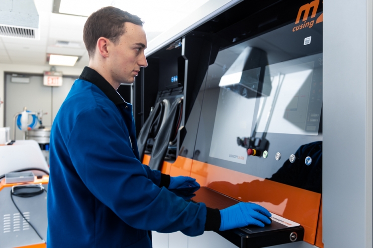 Dr. Glenn Bean operates 3D printing machine. 