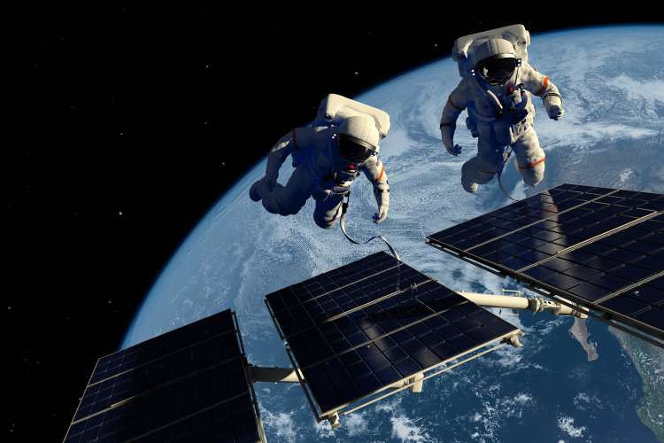Adobe Astronauts floating by panels in space.