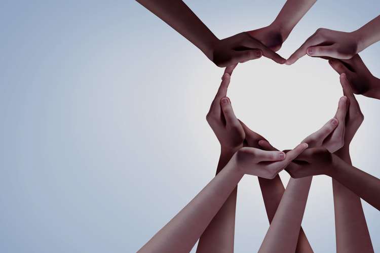 Group of hands that form the shape of a heart