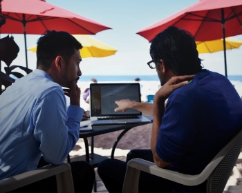 Picture of Dr. Yeoh and Dr. Desai working on AI learning patterns at the beach